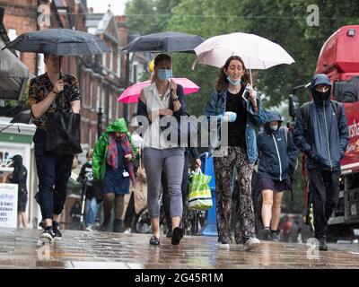 People walk through torrential rain in Hampstead, North London as the