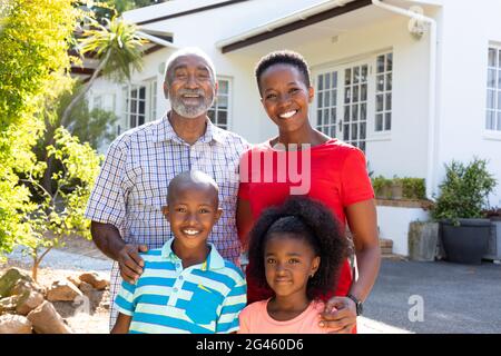 Senior African American couple spending time in their grandson and granddaughter in the garden Stock Photo