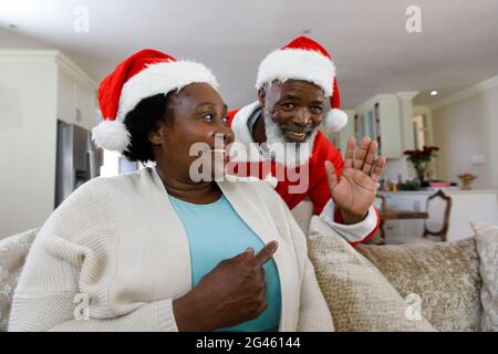 Senior african american couple smiling and wearing santa hats Stock Photo