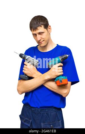A young utility worker holds electric screwdrivers in his hands. Portrait. The guy crossed his arms with the instrument on his chest. Isolated on a white background. Stock Photo