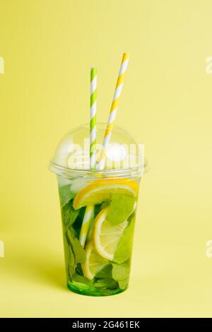 Mojito and Lemonade summer cold drink in a plastic glass with a straw.  Coctail with mint, lemon, lime and ice. Serve at the bar. Beverage closeup  Stock Photo - Alamy