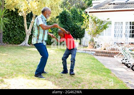 Senior African American man and his grandson spending time together in their garden on a sunny day Stock Photo