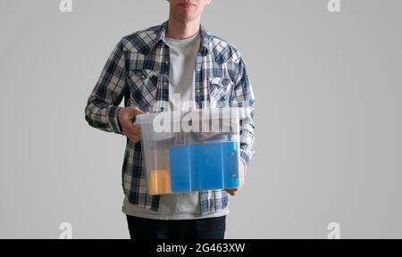 young man holding a plastic box container with things stored inside Stock Photo