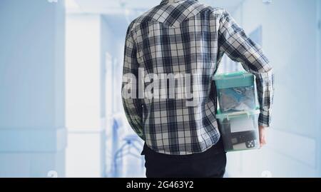 young man holding a plastic box container with things stored inside Stock Photo