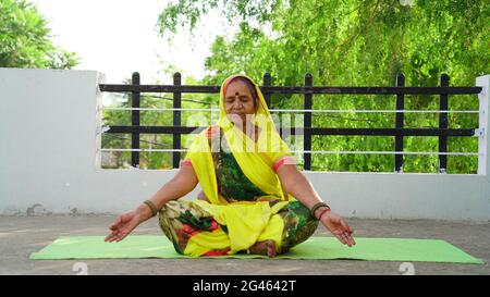 indian village woman doing yoga at home. yoga day concept Stock Photo