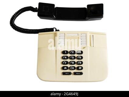 Landline corded push-button telephone isolated on white background. A beige plastic telephone with a receiver on a wire. Old model. Top view Stock Photo