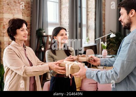 Young man giving presents to his wife and mother-in-law for women day Stock Photo