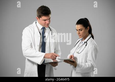 Caucasian female and male doctors on grey background Stock Photo