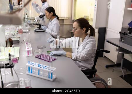 Middle aged female scientist working with blood tests in flasks Stock Photo
