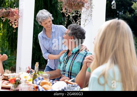 Caucasian family sitting at table during a family lunch in the garden Stock Photo