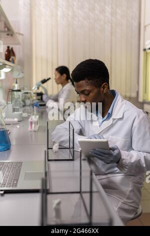 Young male scientist in whitecoat experimenting with white mice in laboratory Stock Photo