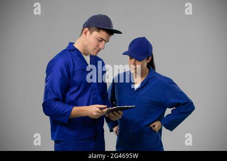 Caucasian male and female engineers on grey background Stock Photo