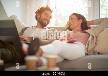 Young cheerful business couple enjoying working from home in a relaxed atmosphere. Business, people, work from home Stock Photo