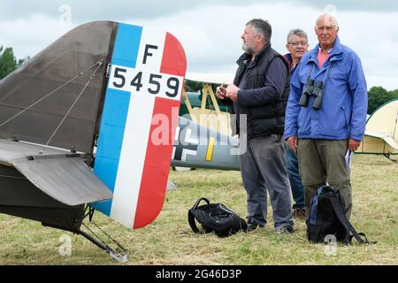 Turweston airfield, Buckinghamshire, UK - Saturday 19th June 2021  - Pilots and aviation enthusiasts enjoy the chance to attend the Air Britain Fly-In at Turweston airfield today on an overcast summers day. Photo shows aviation enthusiasts beside a replica WW1 era SE5a fighter. Photo Steven May / Alamy Live News Stock Photo