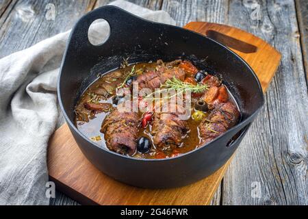 Modern style traditional slow cooked German beef roulades with vegetable and olives in spicy gravy sauce as close-up in a design Stock Photo