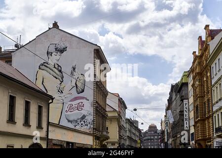 Large street mural of a woman in 1940s style womenswear and a Pepsi-Cola bottle cap painted on the side of building in Prague, Czech Republic Stock Photo