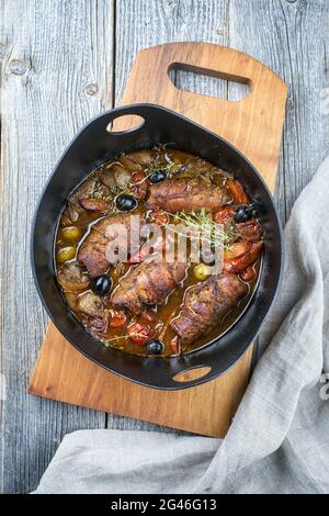 Modern style traditional slow cooked German beef roulades with vegetable and olives in spicy gravy sauce offered as top view in Stock Photo