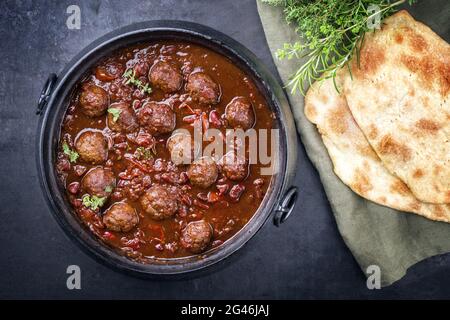 Traditional slow cooked American Tex-Mex meatballs chili with mincemeat and beans in a spicy sauce offered with pita bread as to Stock Photo