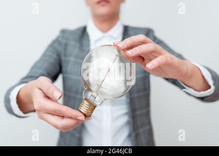 Lady Holding Lamp With Formal Outfit Presenting New Ideas For Project, Business Woman Showing Bulb With Two Hands Exhibiting New Stock Photo