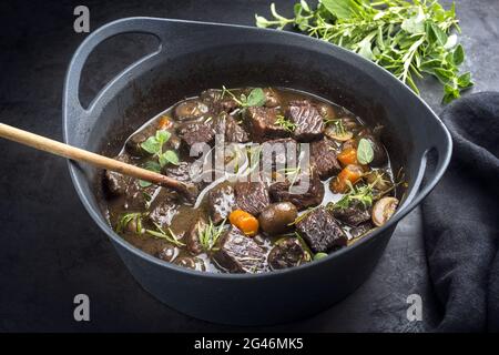Modern style traditional French boeuf bourguignon with mushrooms and carrots in red wine sauce served as close-up in a Design ca Stock Photo