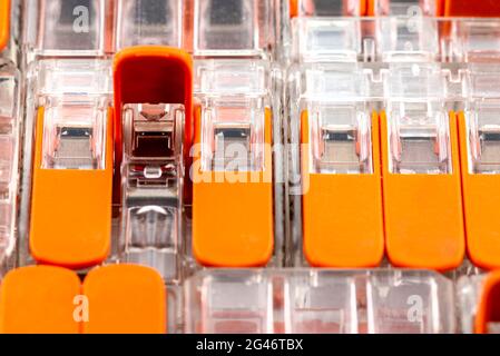 Background made of multiple couplers for strands and solid conductors for electric cables, with a one open levers. Stock Photo
