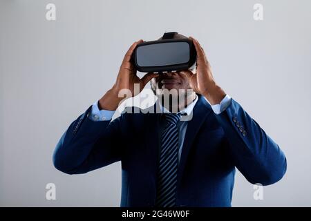 African american businessman wearing vr headset smiling against grey background Stock Photo