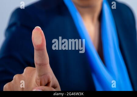 Close up of businesswoman touching invisible screen against grey background Stock Photo