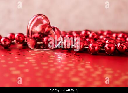 Shining transparent heart and a group of red beads. Perfect Valentine's Day greeting card background. Stock Photo