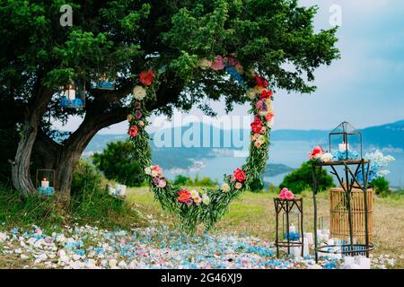 Round wedding arch of flowers and olive branches. Hanging on the Stock Photo