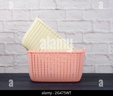 Stack of plastic empty laundry baskets on wooden blue table Stock Photo