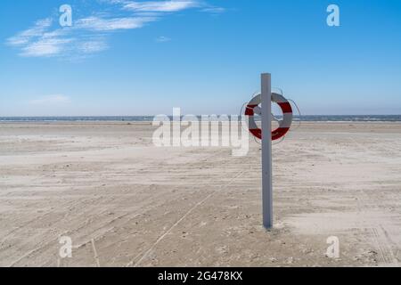 Rescue station and flotation ring on an endless sandy beach on the Wadden Sea island coast of western Denmark Stock Photo