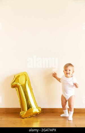 Little cute girl stands near the inflatable number one Stock Photo