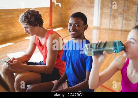 High school kids relaxing on bench Stock Photo