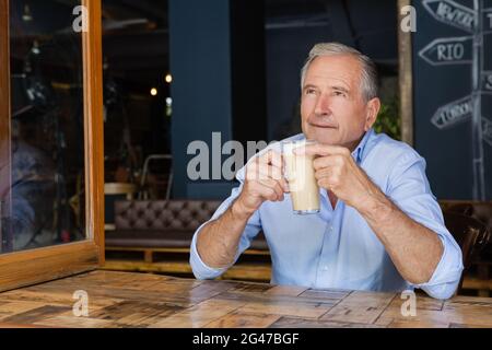 Senior thoughtful man holding cold coffee Stock Photo