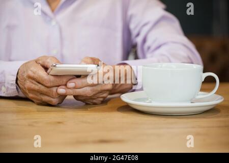 Midsection of senior woman using smart phone Stock Photo