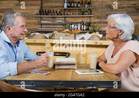 Senior couple interacting while having coffee Stock Photo