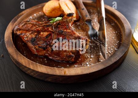 medium rare Steak on bone Veal rib with potato on a wooden plate Stock Photo