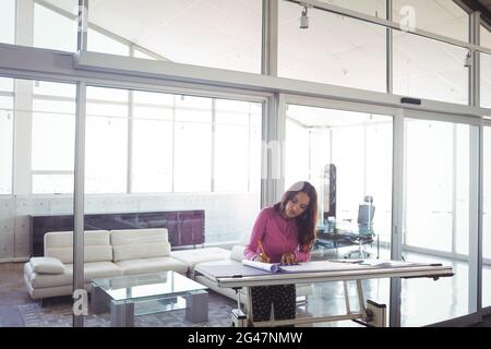 Female interior designer making diagram on paper in office Stock Photo