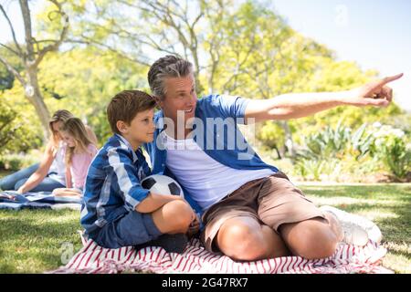 Father and son looking at the distance in park Stock Photo