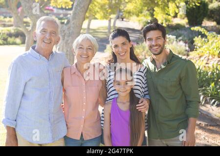 Happy family standing together in the park Stock Photo