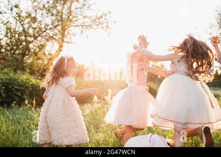Group of children play soap bubble in playground with sunset background, kid, child, school, play and summer background. Happy childhood Stock Photo
