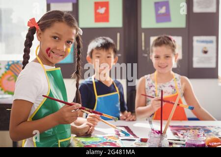 Portrait of happy schoolkids practicing drawing Stock Photo