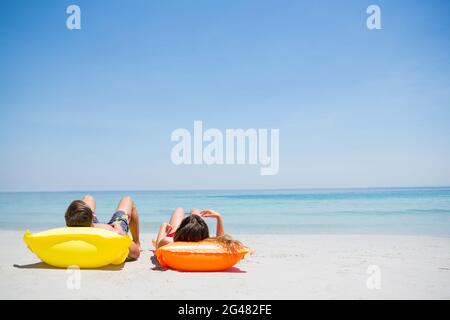 Couple relaxing at beach Stock Photo