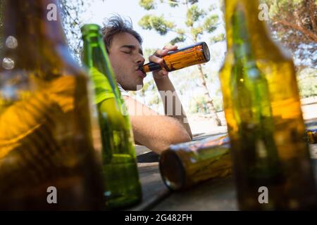 Man drinking beer from bottle in the park Stock Photo