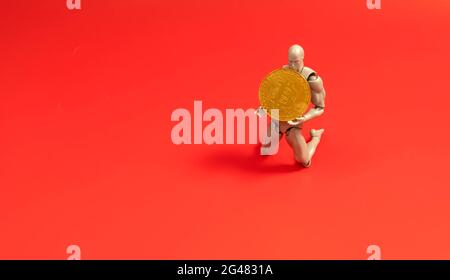 Bitcoin Cryptocurrency. Digital Currency of The Future. Selective focus of a doll on the knee holding bitcoin replica. Stock Photo