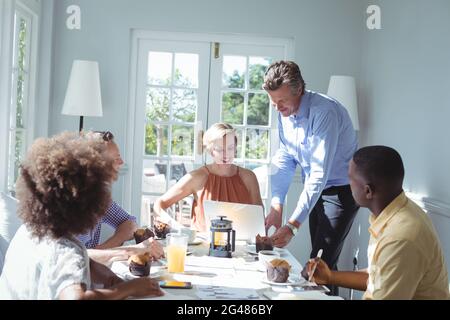 Group of executive using laptop while having breakfast Stock Photo