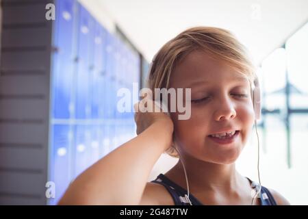 Elementary student with eyes closed listening music through headphones Stock Photo