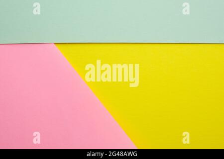 Abstract colored background made with three pieces of cardboard top view. Segmented background of green, yellow and pink. Different colors paper backg Stock Photo