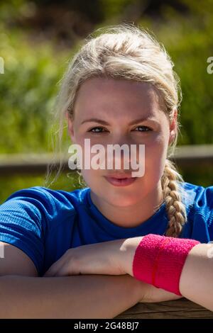 Fit woman leaning on hurdles during obstacle course training in the boot camp Stock Photo