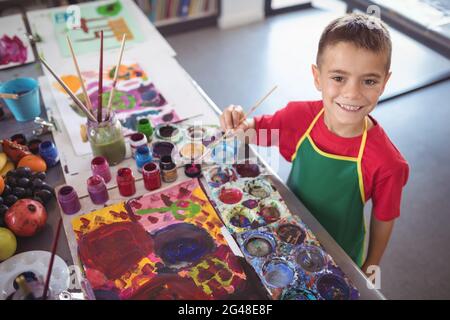 High angle portrait of boy painting at desk Stock Photo